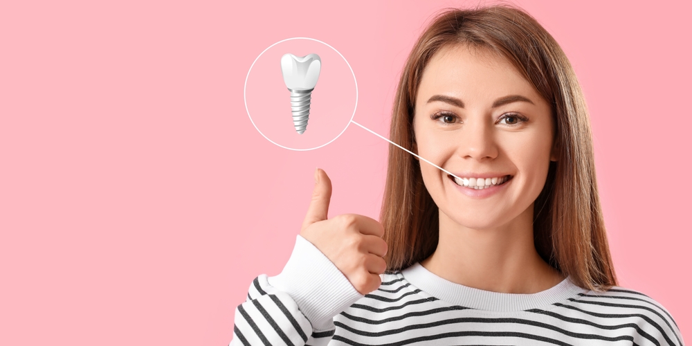 Woman smiling with a thumbs up, and an image of a dental implant and crown, pointing to her mouth. Woman smiling with a thumbs up, and an image of a dental implant and crown, pointing to her mouth.